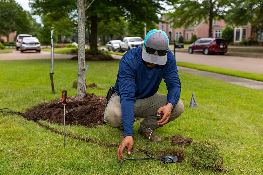 A man repairs outdoor lighting system in Raleigh.