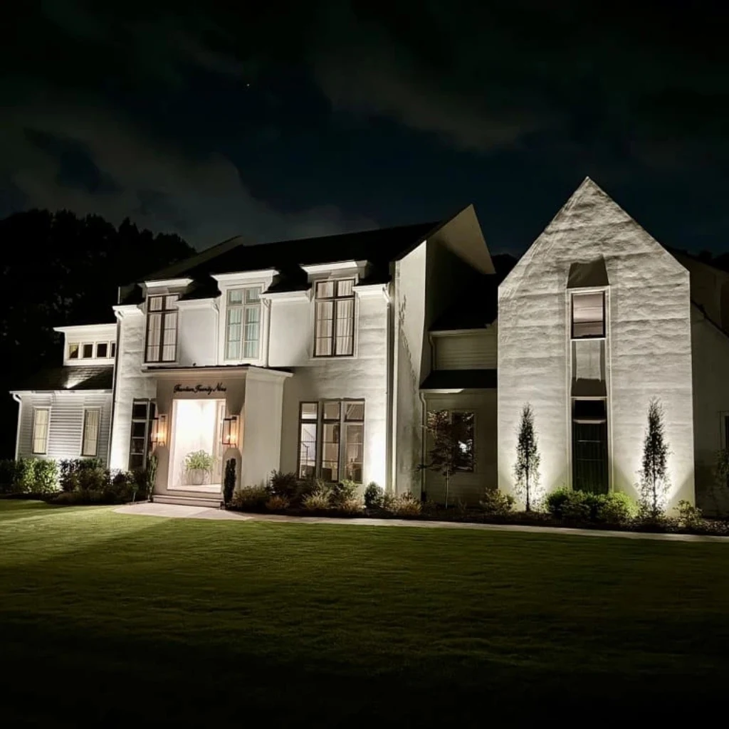 A modern luxury suburban home photographed at dusk, featuring outdoor lighting installation in Raleigh, NC.