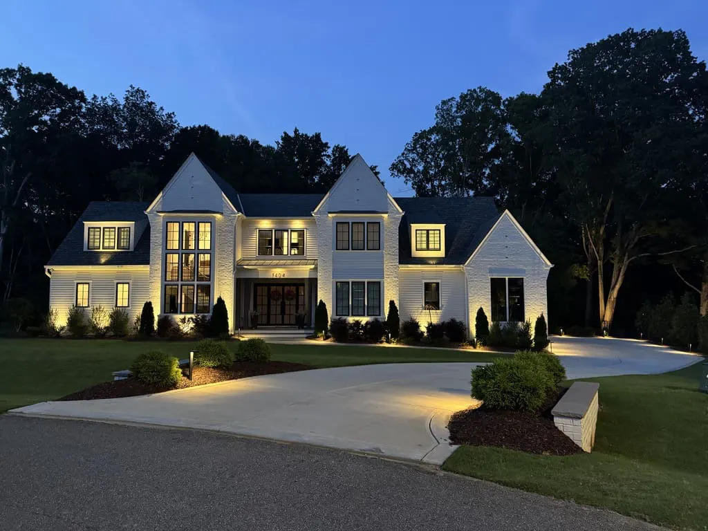 a modern white brick home featuring outdoor lighting installation in raleigh nc.